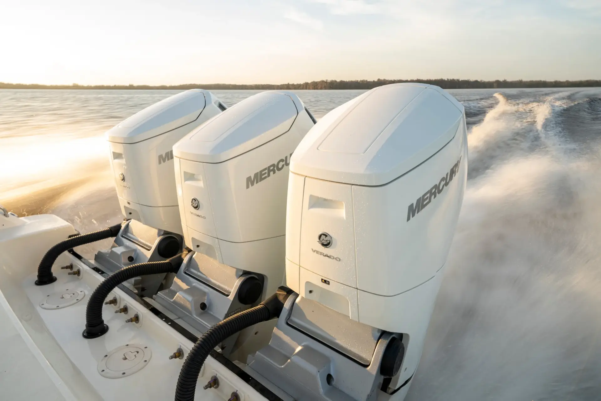 Triple Mercury Verado outboards at speed at sunset