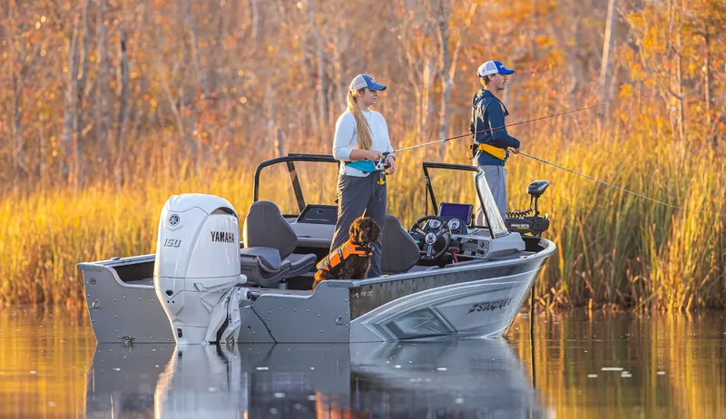 Anglers casting from an aluminum center console boat with a Yamaha outboard at golden hour